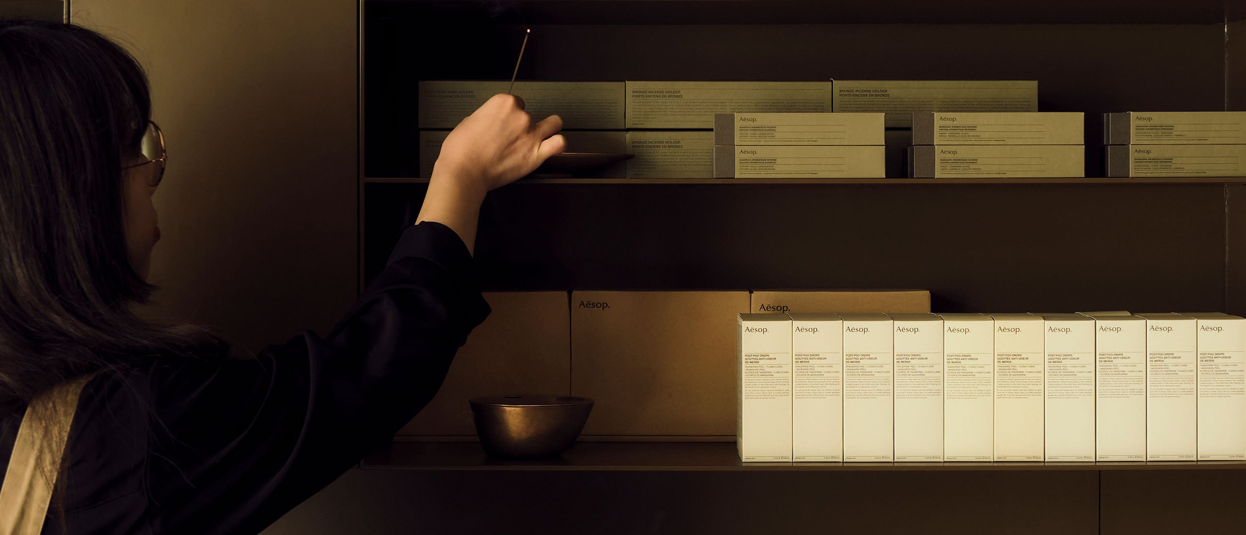 An Aesop consultant lights incense and places it in our brass incense holder.