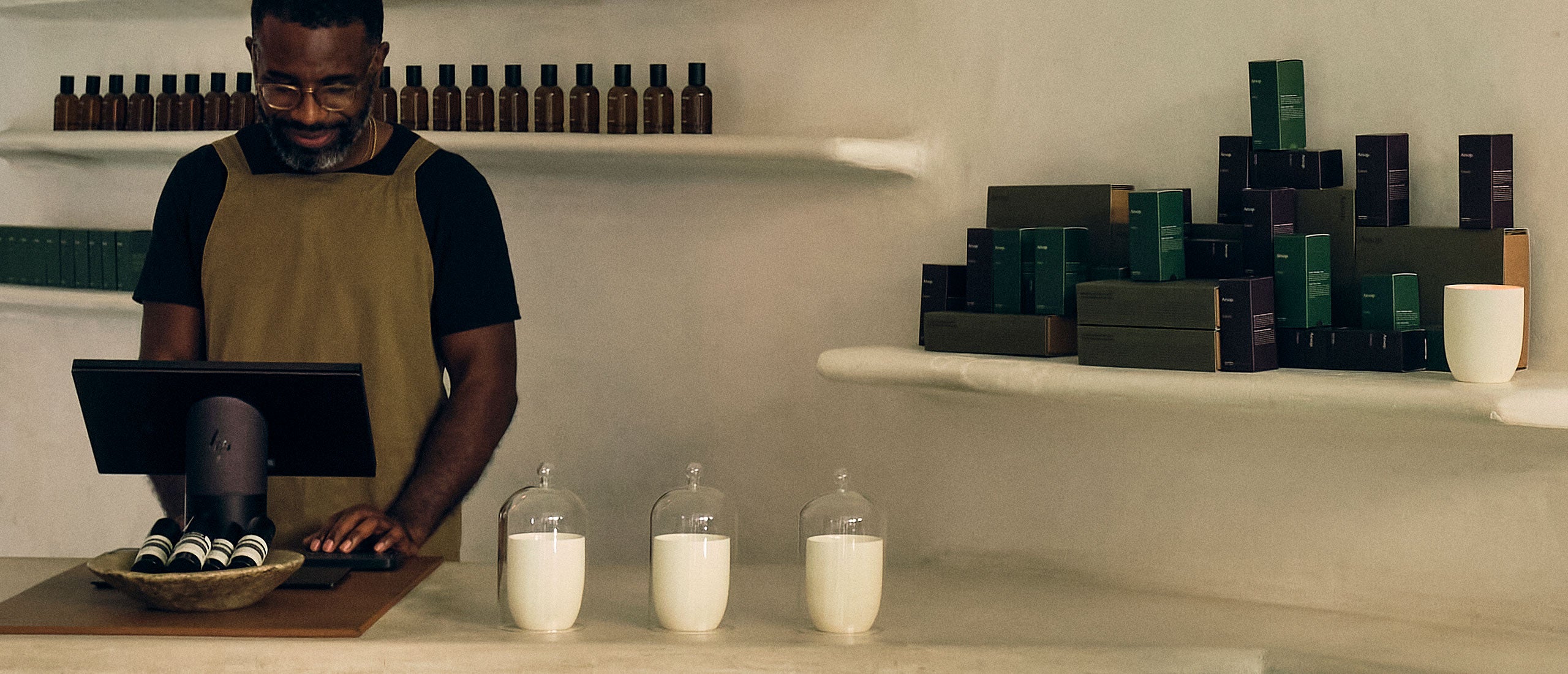 An Aesop consultant stands ready to help a customer with an order.