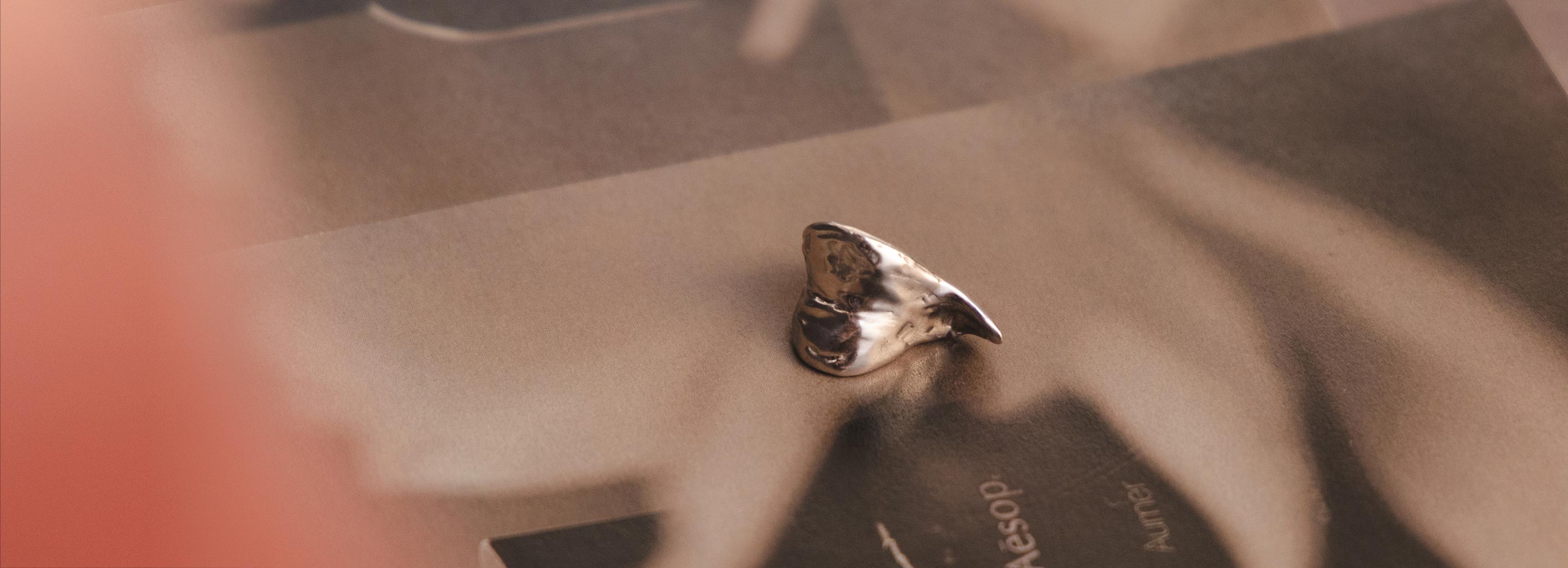 A silver ear cuff placed on a textured background