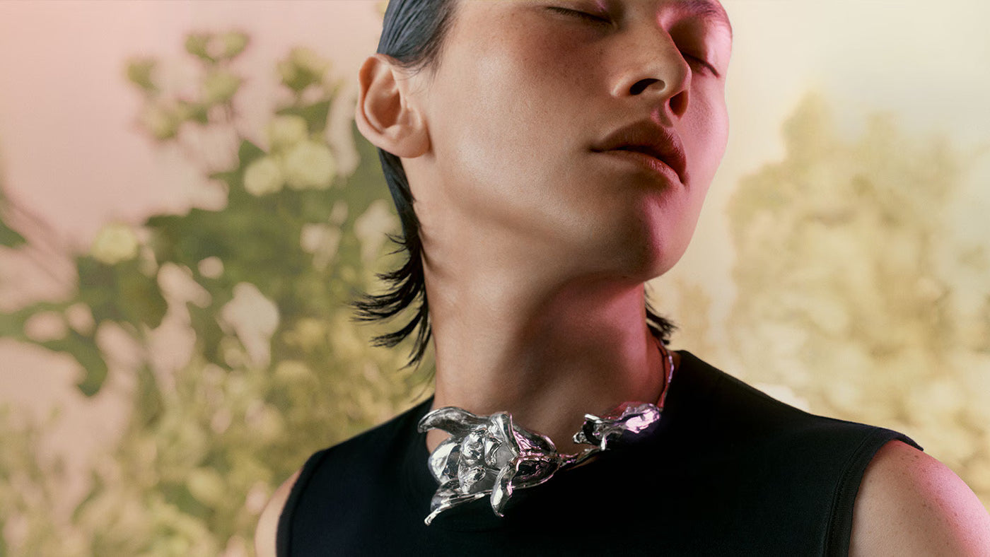 Individual wearing a silver flower necklace 