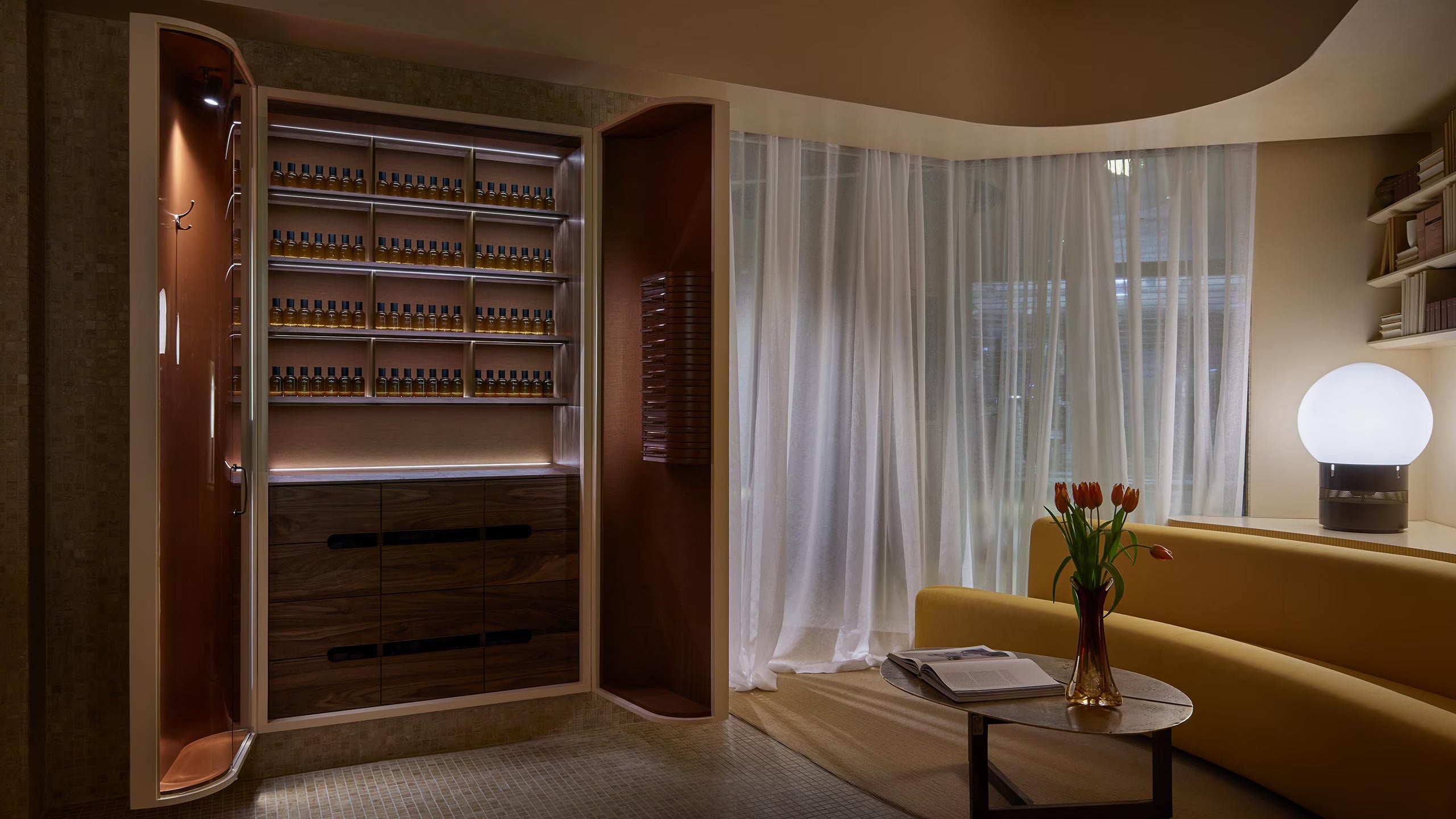 An armoire with doors open in a tiled room alongside a citrus toned sofa.
