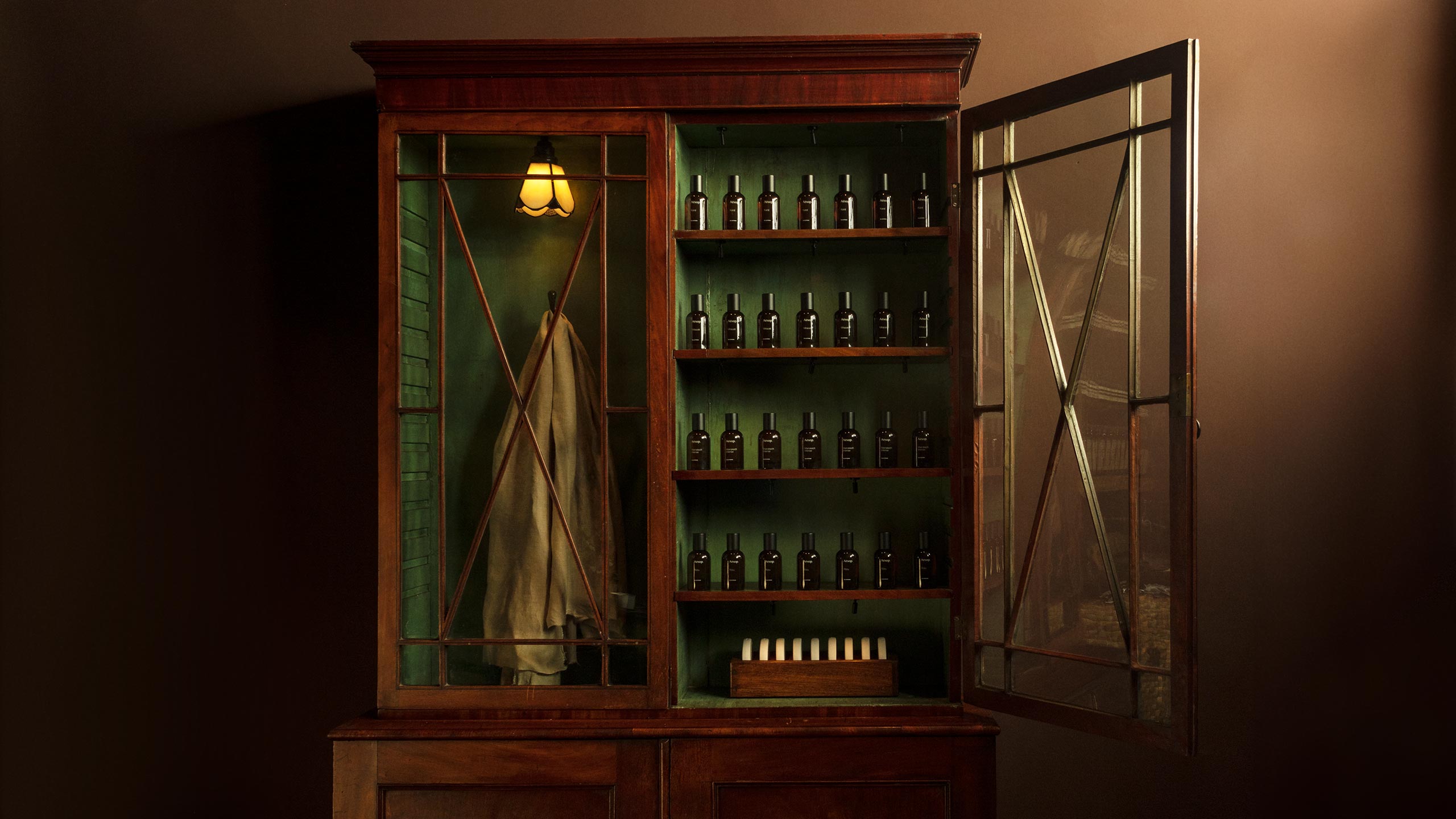 A timber and glass cabinet filled with amber bottles.