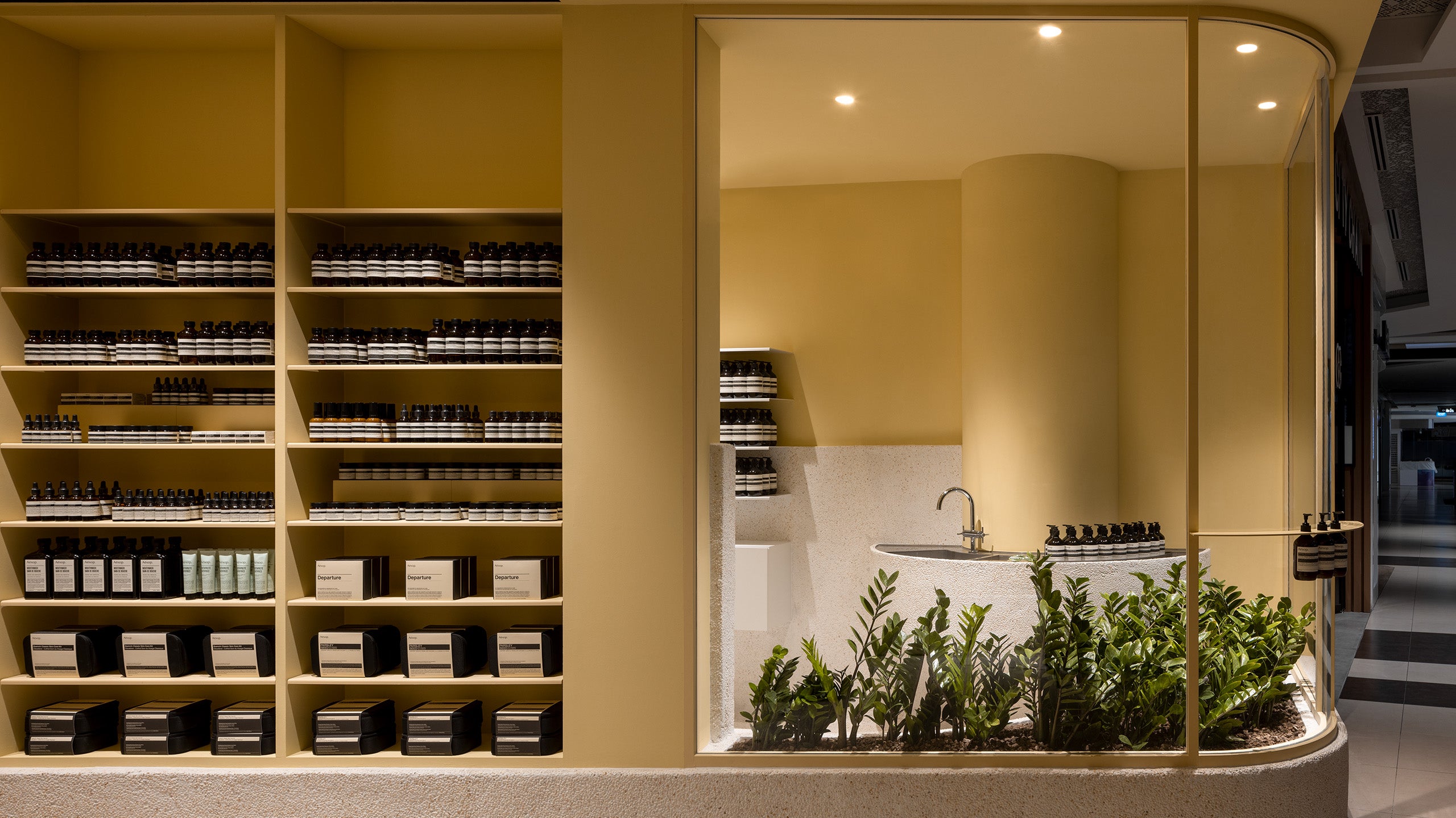 The smooth shelves on the surrounding walls are lined with Aesop products.